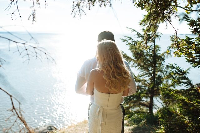 Anchorage Wedding Portraits with bright sun and bride and groom looking over water